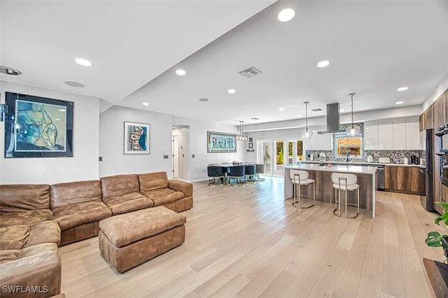 living room featuring recessed lighting, visible vents, and light wood finished floors
