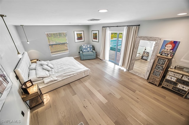 bedroom with access to exterior and light hardwood / wood-style floors