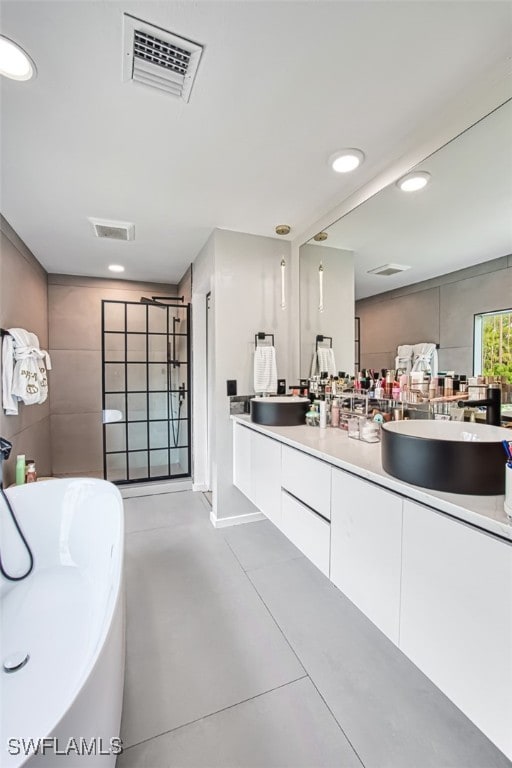 675 Logan Blvd S, Naples, FL 34119 - full bath with double vanity, a freestanding tub, recessed lighting, and finished concrete floors