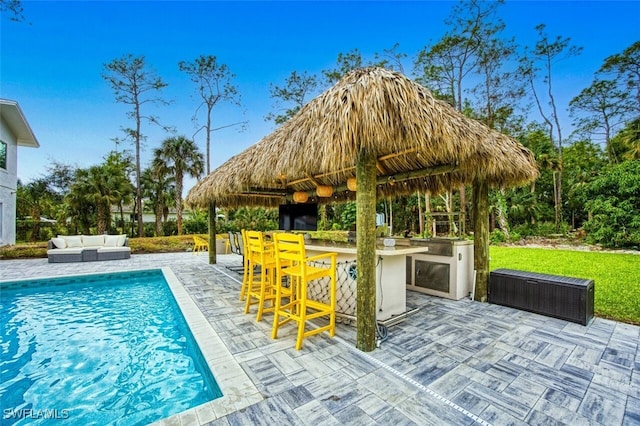 view of pool featuring a gazebo, an outdoor living space, exterior bar, and a patio area