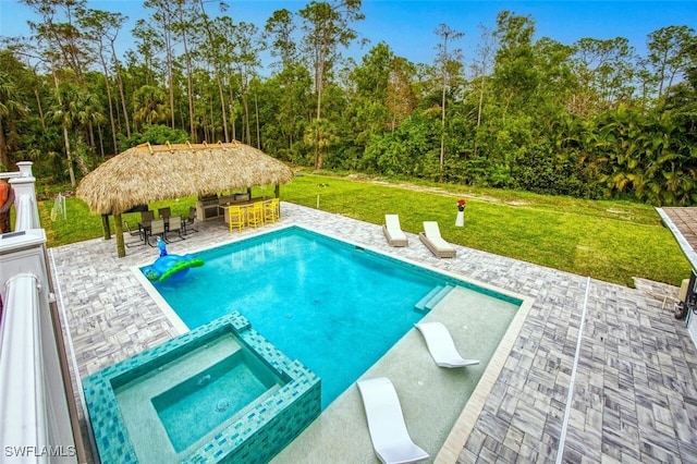 view of swimming pool with a patio, a lawn, exterior bar, an in ground hot tub, and a gazebo