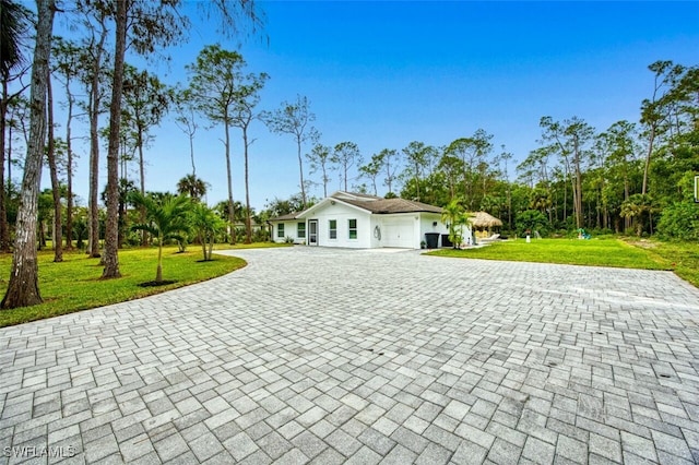 675 Logan Blvd S, Naples, FL 34119 - view of front facade with decorative driveway, an attached garage, and a front yard