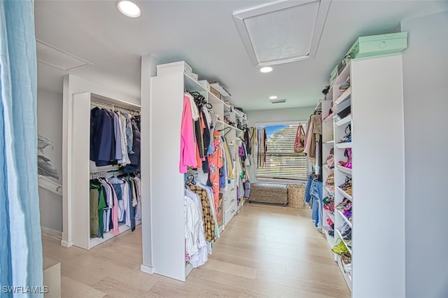 walk in closet with light hardwood / wood-style floors