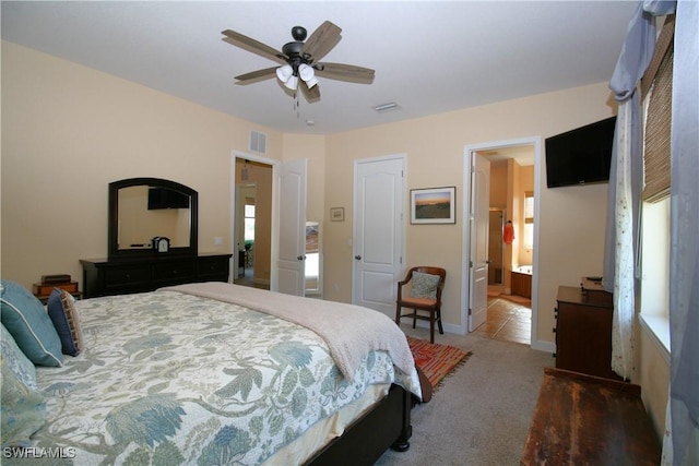 carpeted bedroom featuring ceiling fan and ensuite bathroom