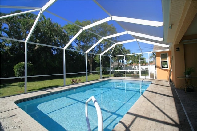 view of swimming pool featuring a lanai, a patio area, and a lawn