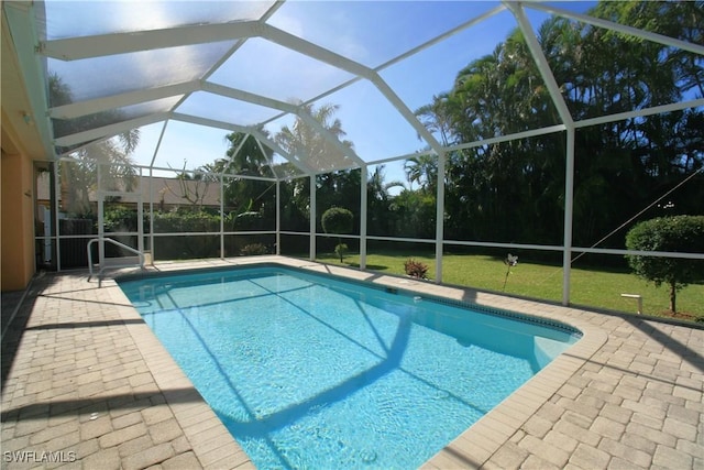 view of pool featuring a patio, glass enclosure, and a lawn