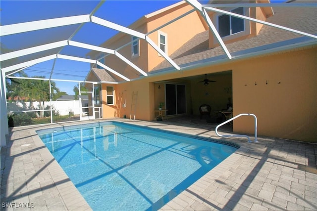 view of pool featuring glass enclosure, ceiling fan, and a patio area