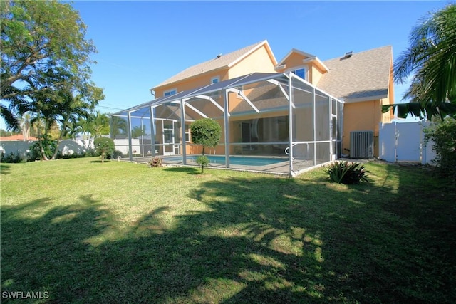 back of property with a yard and a lanai