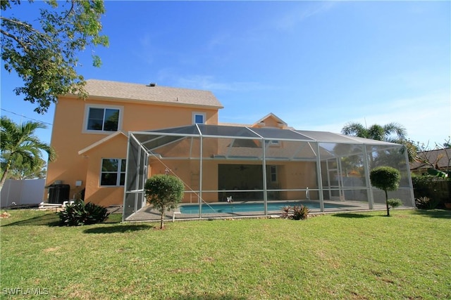 back of house with a lanai, a lawn, and cooling unit