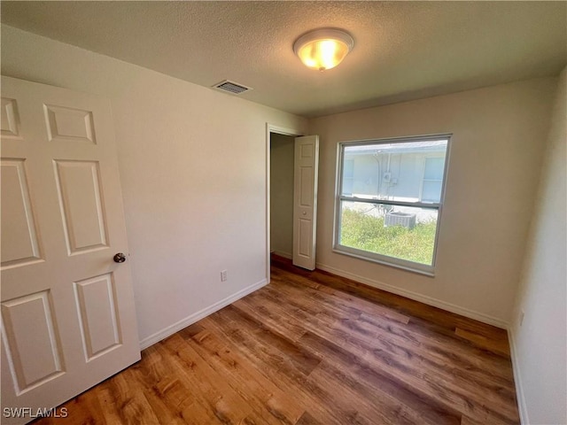 unfurnished bedroom with hardwood / wood-style floors and a textured ceiling