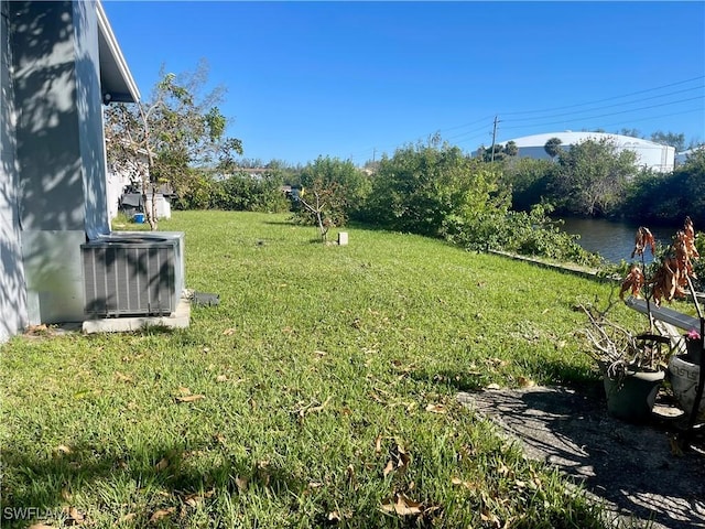 view of yard featuring central AC unit and a water view