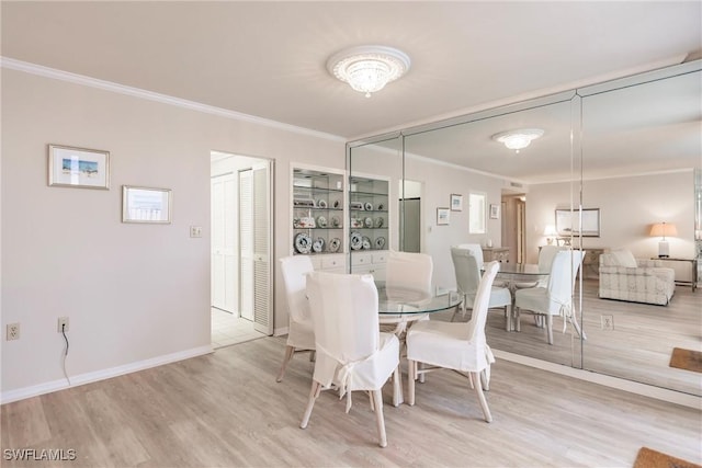 dining room featuring light hardwood / wood-style floors and ornamental molding