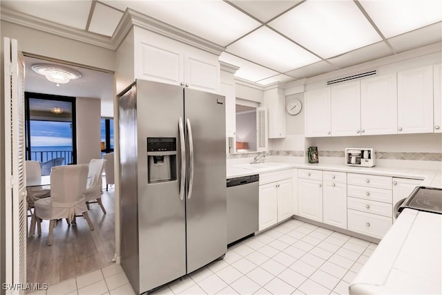 kitchen with sink, light hardwood / wood-style flooring, appliances with stainless steel finishes, white cabinets, and ornamental molding