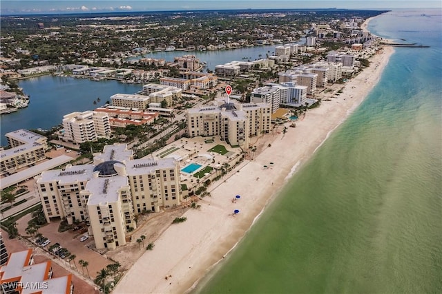 birds eye view of property with a water view and a beach view