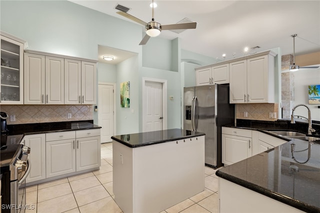 kitchen with appliances with stainless steel finishes, tasteful backsplash, a ceiling fan, and a sink