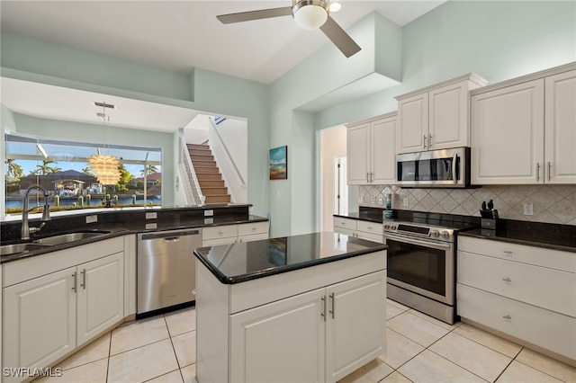 kitchen with sink, white cabinets, stainless steel appliances, and light tile patterned floors