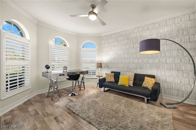 living room with wood finished floors, ceiling fan, crown molding, and baseboards