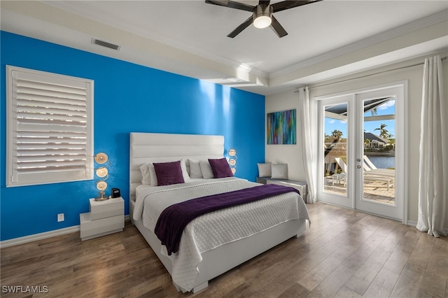 bedroom featuring dark hardwood / wood-style flooring, ornamental molding, access to outside, ceiling fan, and a water view