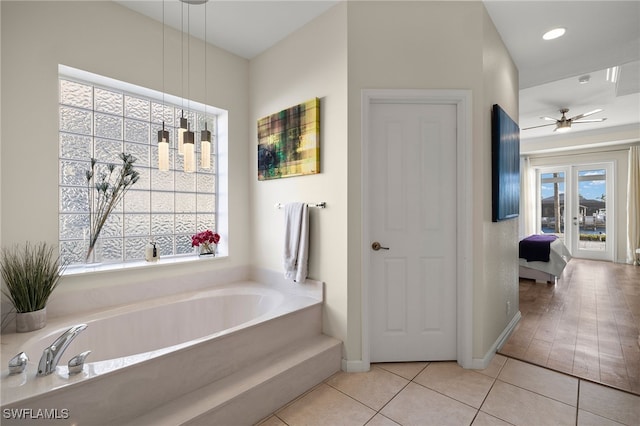 bathroom featuring a tub, ceiling fan, and tile patterned flooring