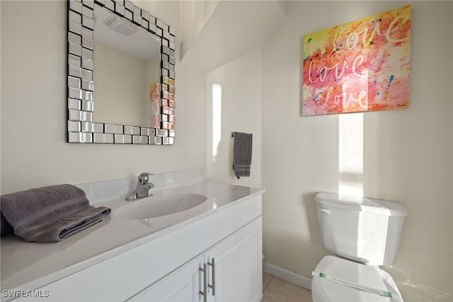 half bath featuring toilet, tile patterned floors, vanity, and baseboards