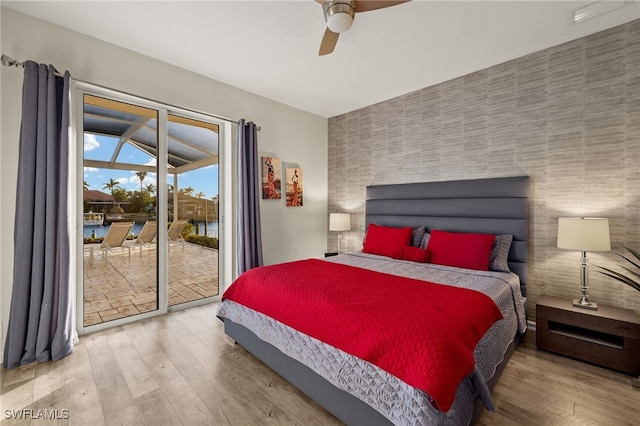 bedroom with access to exterior, hardwood / wood-style flooring, and ceiling fan