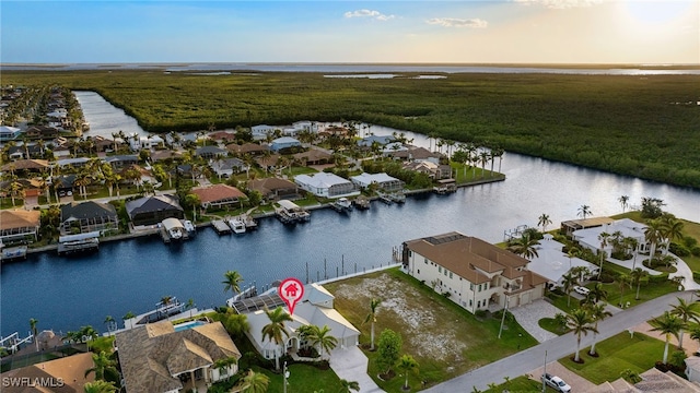 aerial view at dusk featuring a water view