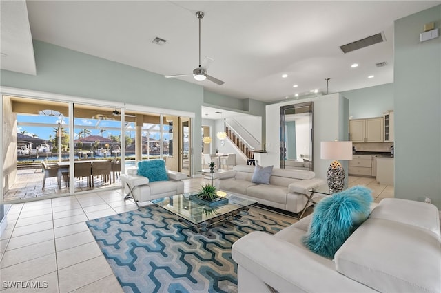 living room featuring ceiling fan, light tile patterned flooring, and a healthy amount of sunlight