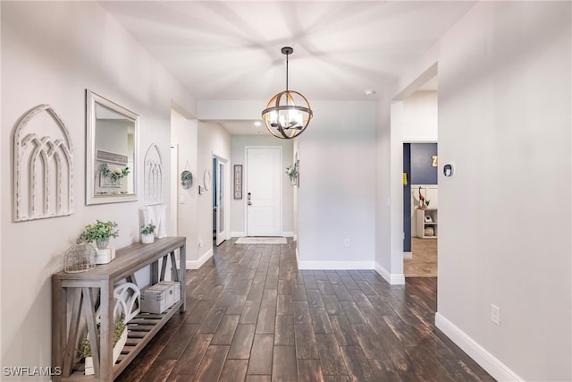 hallway featuring dark wood-type flooring and a chandelier