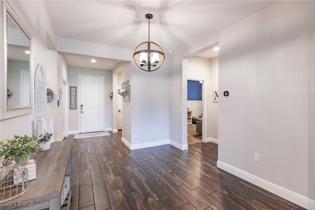 entryway featuring dark hardwood / wood-style flooring and an inviting chandelier