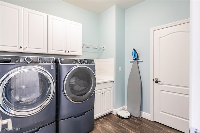 laundry area with separate washer and dryer, dark hardwood / wood-style floors, and cabinets