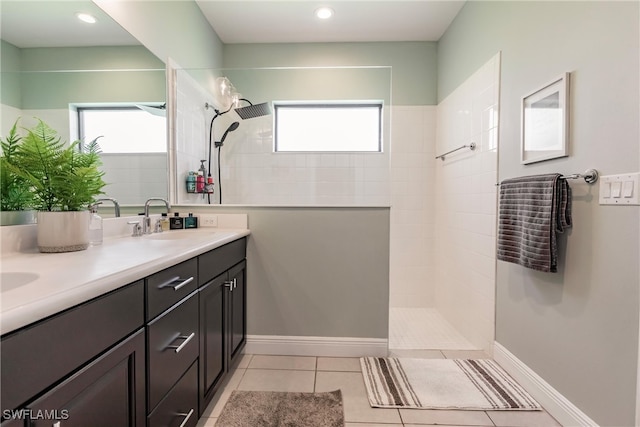 bathroom with tile patterned flooring, vanity, and a healthy amount of sunlight