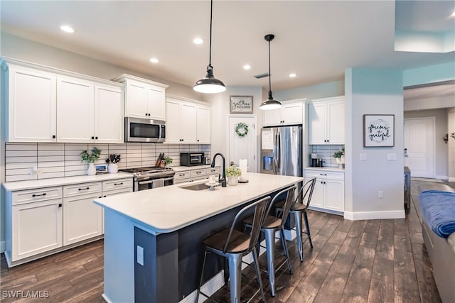 kitchen with dark hardwood / wood-style flooring, white cabinetry, sink, and stainless steel appliances