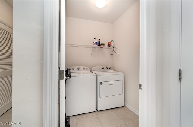 clothes washing area featuring washer and dryer and light tile patterned floors