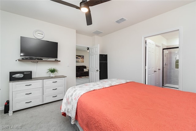 carpeted bedroom with ensuite bath and ceiling fan