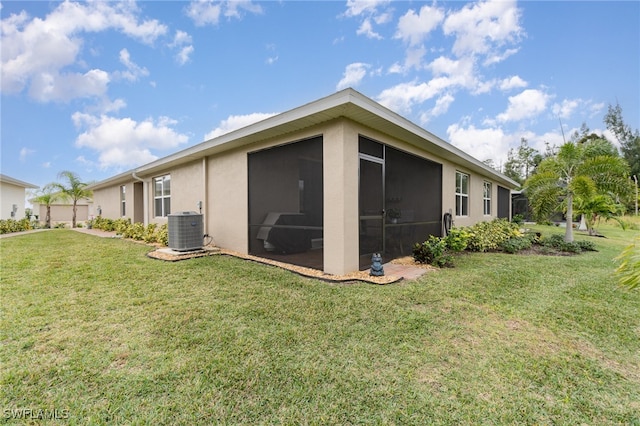 view of side of home featuring central AC unit, a sunroom, and a lawn