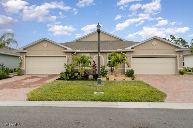 single story home featuring a garage and a front lawn