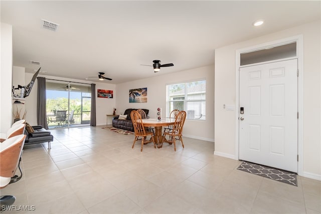 tiled dining room with plenty of natural light and ceiling fan