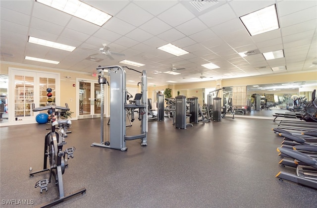 gym featuring a drop ceiling, ceiling fan, and french doors