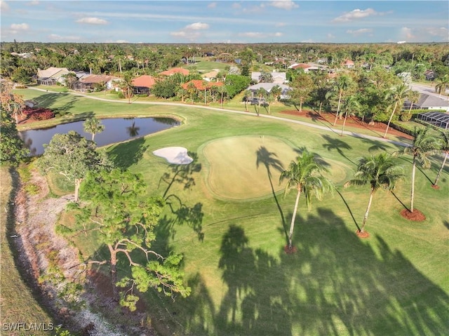 drone / aerial view featuring golf course view and a water view