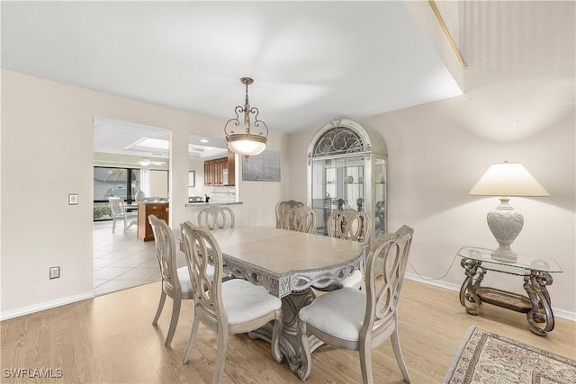 dining room featuring light wood-style flooring and baseboards