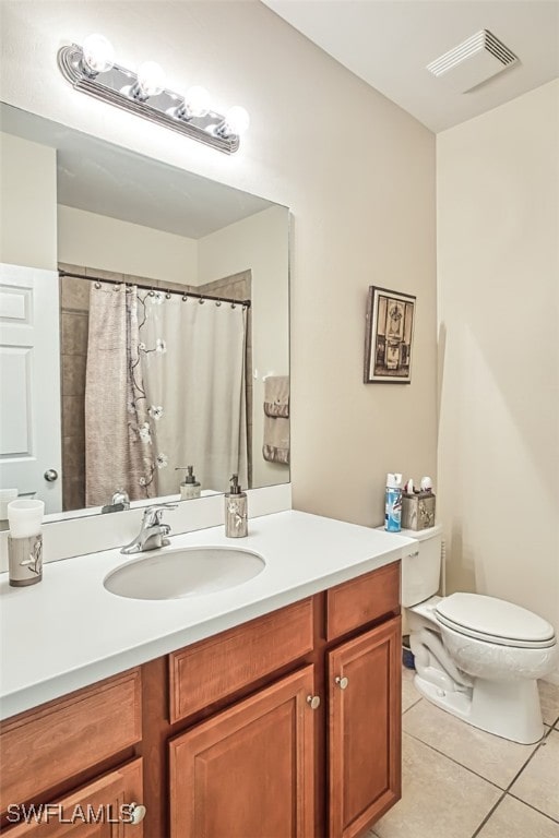 bathroom featuring tile patterned floors, vanity, toilet, and walk in shower