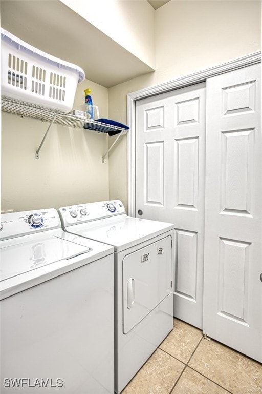 laundry area with independent washer and dryer and light tile patterned flooring