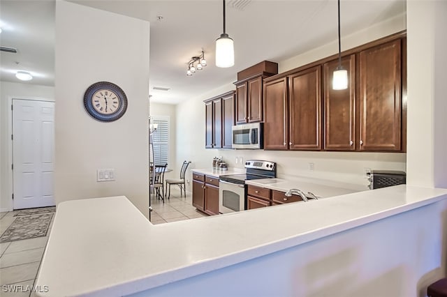 kitchen with pendant lighting, light tile patterned flooring, and appliances with stainless steel finishes