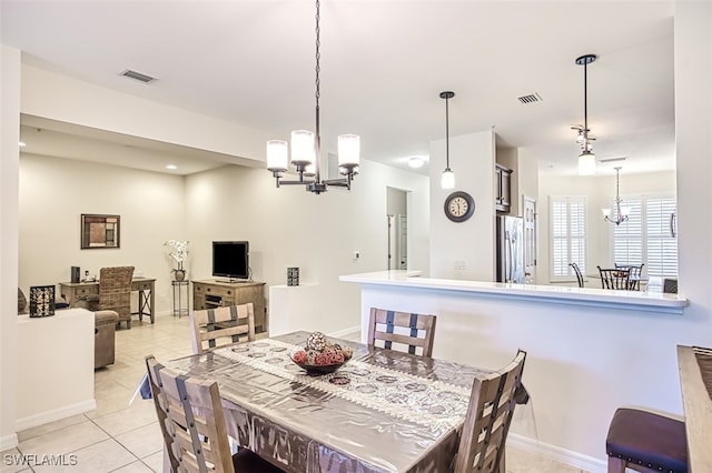 dining area featuring light tile patterned flooring and a chandelier