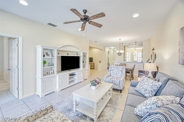 living room with light tile patterned floors and ceiling fan with notable chandelier