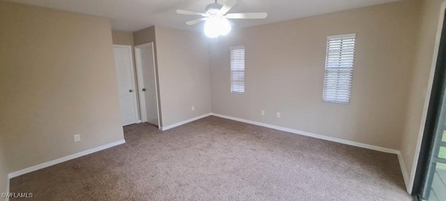 empty room with ceiling fan, light colored carpet, and a wealth of natural light