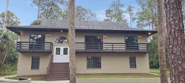 view of front of property featuring a front yard and a balcony