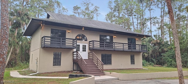 front facade featuring a balcony and a front lawn