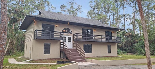 880 Wilson Blvd N, Naples, FL 34120 - view of front of home with a balcony, a front lawn, stucco siding, stairway, and roof with shingles