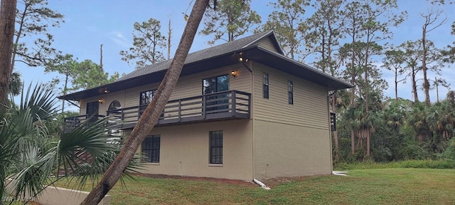 view of property exterior featuring a balcony and a yard